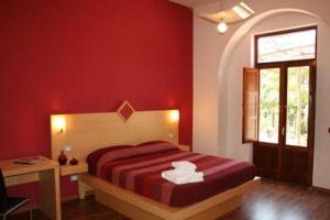 una camera rossa con letto e finestra di Bellaria Relais a Piano di Sorrento