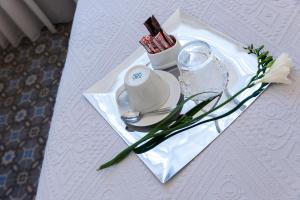 a table with a white plate with a candle and a glass at Old Town Inn in Kavála