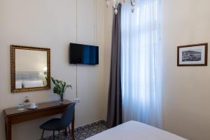 a room with a desk and a mirror and a bed at Old Town Inn in Kavála