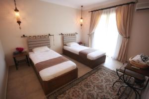 a bedroom with two beds and a large window at Dardanos Hotel in Patara
