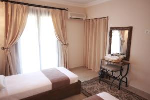 a bedroom with two beds and a mirror and a chair at Dardanos Hotel in Patara
