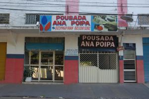 a store with a sign on the side of a building at Pousada Ana Poipa in Goiânia