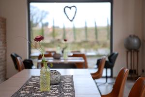 a vase on a table with a flower in it at Vinotel Dollt-Kern in Flemlingen +9 photos