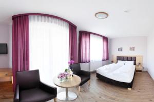 Habitación de hotel con cama, mesa y sillas en Magnolia- Pokoje Gościnne, en Zgorzelec