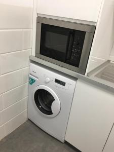 a microwave on top of a washing machine in a kitchen at Apartamento Foro Romano in Cartagena