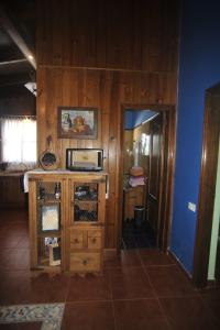 Habitación con armario de madera y microondas. en Finca las Aguelillas en La Orotava