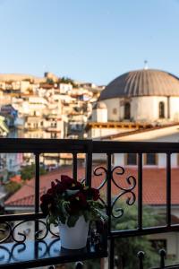 a plant on a balcony with a view of a city at Old Town Inn in Kavala