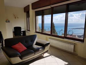 uma sala de estar com um sofá e vista para o oceano em Sicula em Taormina
