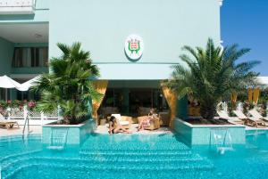 a group of people sitting around a swimming pool at Hotel Montecarlo in Bibione