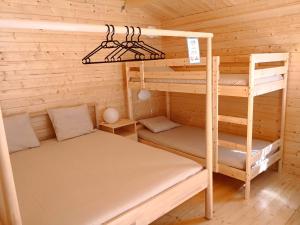 a bedroom with bunk beds in a wooden cabin at Camping Piccolo Paradiso in Avegno