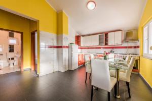 een keuken met een eettafel en gele muren bij House Danica in Obrovac