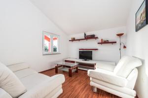een woonkamer met twee witte banken en een tv bij House Danica in Obrovac