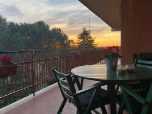 a table and chairs on a balcony with the sunset at Green view apartment in Rome