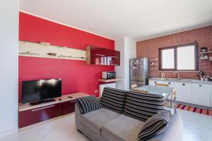 a living room with a couch and a red wall at Terrazza Sul Mare in Trapani