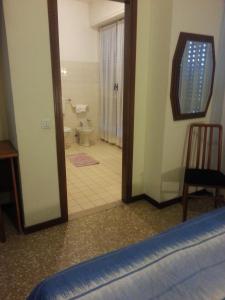 ein Schlafzimmer mit einer Tür, die sich zu einem Bad mit einem WC öffnet in der Unterkunft Hotel Lombardia in Seveso