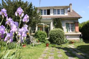 uma casa com flores roxas no quintal em B&B Le Cottage Paris Saclay em Bures-sur-Yvette