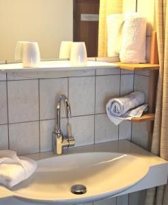 a bathroom with a sink and a mirror and towels at Apartments Auenheim in Prägraten am Großvenediger