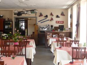 Viviers-du-LacにあるHotel Alain et Martineのテーブルと椅子のあるレストラン、キッチンが備わります。