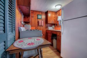 eine Küche mit einem Tisch und einem Kühlschrank in der Unterkunft Cottage Place on Squam Lake - Cabins in Holderness
