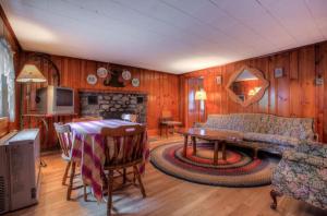 ein Wohnzimmer mit Sofa und Tisch in der Unterkunft Cottage Place on Squam Lake - Cabins in Holderness + 22 Fotos
