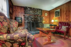 ein Wohnzimmer mit einem Steinkamin und einem Sofa in der Unterkunft Cottage Place on Squam Lake - Cabins in Holderness
