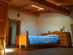 a bedroom with a bed with a blue comforter at Casa Campetta in Comano Terme