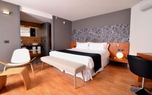 een slaapkamer met een bed, een bureau en een stoel bij BIT Design Hotel in Montevideo