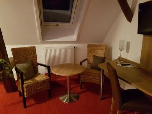 a small room with a table and chairs and a desk at Berg Gasthof Witthoh in Immendingen