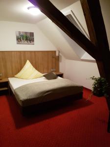 a bed in a room with a red carpet at Berg Gasthof Witthoh in Immendingen