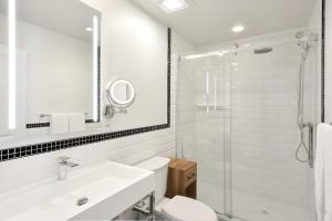 a bathroom with a toilet and a sink and a shower at Hotel Bonaparte in Montréal +25 photos