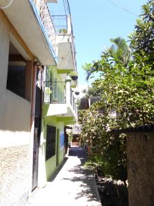 un callejón estrecho entre 2 edificios con balcón en Una Noche Con Mical, en San Pedro La Laguna