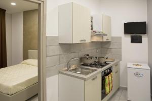 a small kitchen with a sink and a stove at Barone Apartments in Sciacca