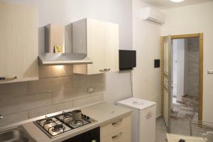 a white kitchen with a stove and a sink at Barone Apartments in Sciacca