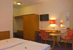 a hotel room with a bed and a table and a desk at Hotel Park Eckersbach in Zwickau