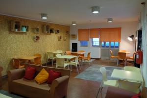 - une salle d'attente avec un canapé, des tables et des chaises dans l'établissement Parque de Campismo Orbitur Viana do Castelo, à Viana do Castelo