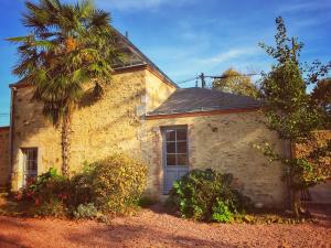 Saint-Michel-Mont-Mercure的住宿－La Mauriere - Puy du Fou，一座古老的石头房子,前面有一棵棕榈树