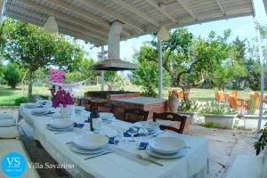 a table set for a meal under a pergola at Villa Savarino in Vittoria