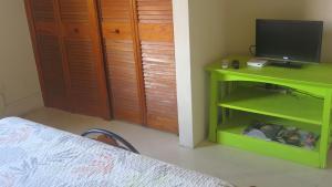 a bedroom with a green table and a television at Gemini House Bed & Breakfast in Christ Church
