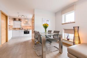a kitchen and dining room with a glass table and chairs at Dalriada Lodges Craigeven in Stonehaven