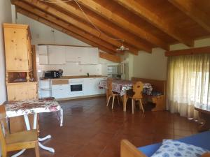 a kitchen with white cabinets and a table and chairs at Casa Campetta in Comano Terme