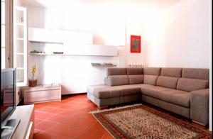 Una sala de estar con un sofá y un televisor. en Casa La Rosa Bianca, en Pesaro
