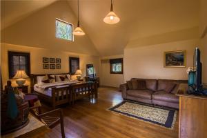 Teakwood villa في مدينة كانشانابوري: غرفة معيشة مع أريكة وطاولة
