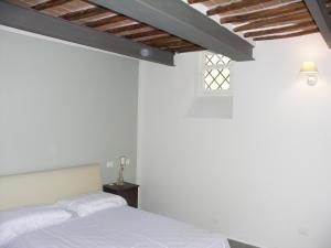 una camera da letto con pareti bianche e un letto bianco di Real Taste of Siena a Siena