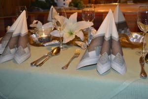 a table with silverware and napkins on a table at Hotel Gasthof Rödertor in Rothenburg ob der Tauber