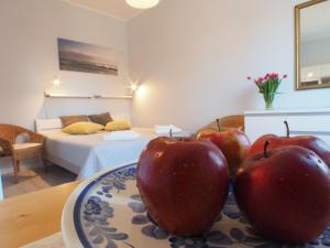 two apples on a plate on a table in a bedroom at Grand Tourist Gemini in Gdańsk