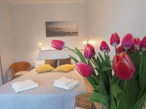 a bedroom with a bed with pink tulips on it at Grand Tourist Gemini in Gdańsk