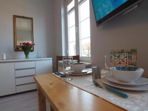 a dining room with a table with plates and glasses at Grand Tourist Gemini in Gdańsk