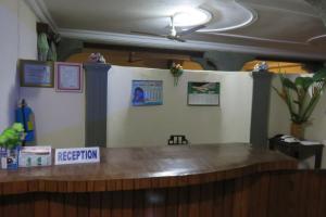 eine Bar in einem Restaurant mit einem Schild, das die Rezeption liest in der Unterkunft Hotel Agbeviade in Palimé