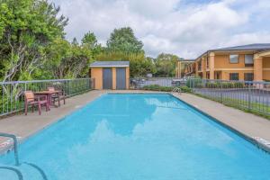 a pool with a table and chairs next to a house at Days Inn by Wyndham Blythewood North Columbia in Blythewood