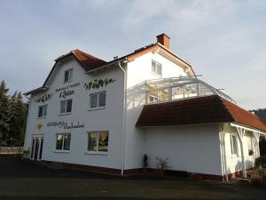 une maison blanche avec une véranda sur le côté dans l'établissement Weinbau & Pension "8Zeilen", à Golk